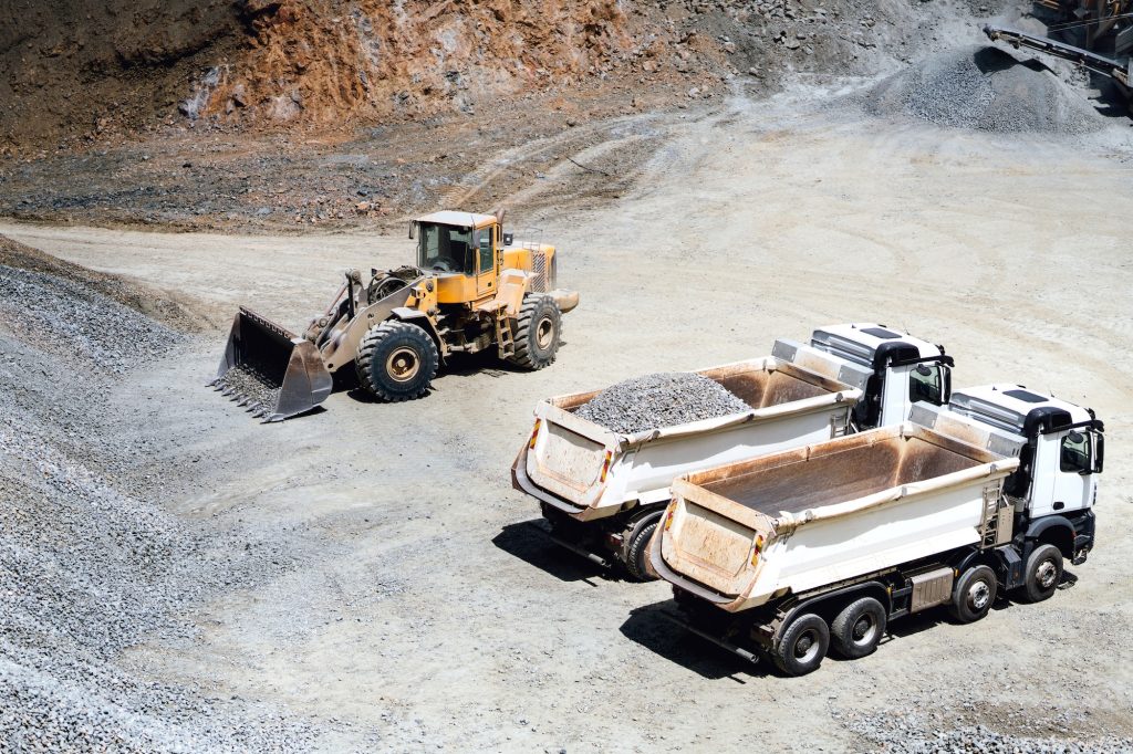 wheel loader working on site and loading dumper trucks.